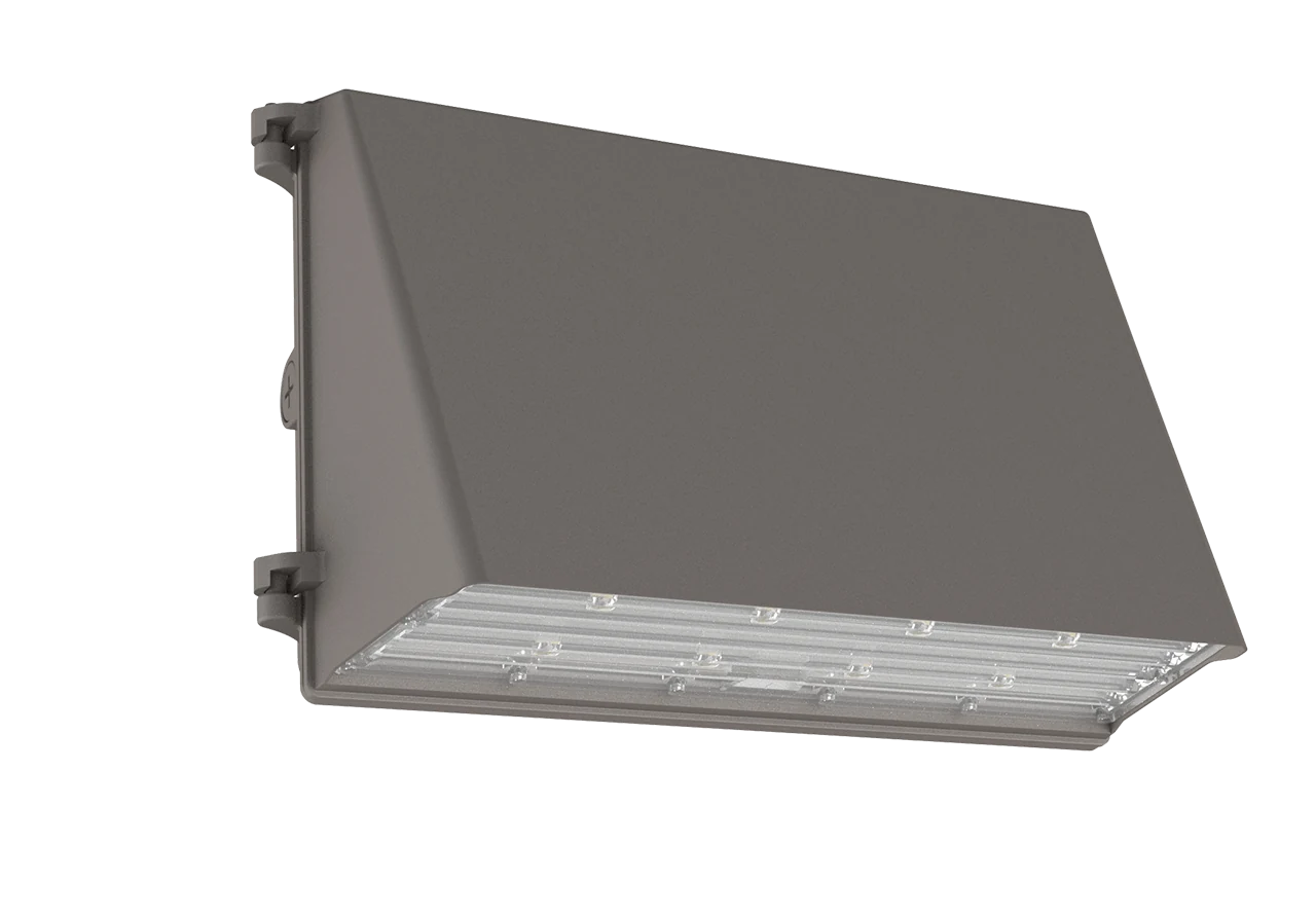 Watchtower wall pack mounted on commercial perimeter wall, angled top face shielding all uplight, full-cutoff distribution patterning the wall below